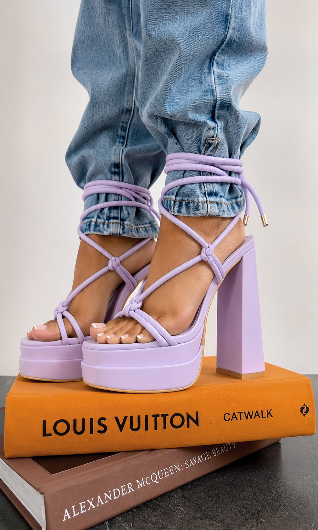 AFFIRM ZAPATILLAS MORADAS DE MAXI PLATAFORMA CON LACE-UP PARA COMBINAR CON PANTALON DE MEZCLILLA MIENTRAS PISA LIBROS DE MODA EN SESION 