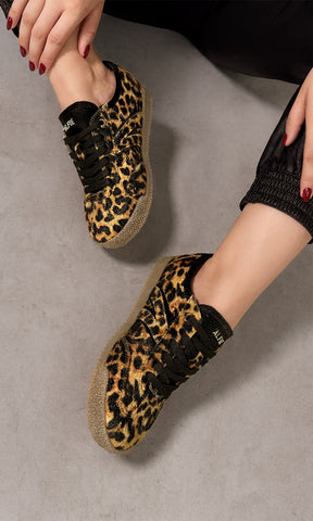 ALIX COMO COMBINAR SNEAKERS DE ANIMAL PRINT CON PANTALON NEGRO TIPO JOGGER Y SUDADERA ROJA PARA VERSE EN TENDENCIA 