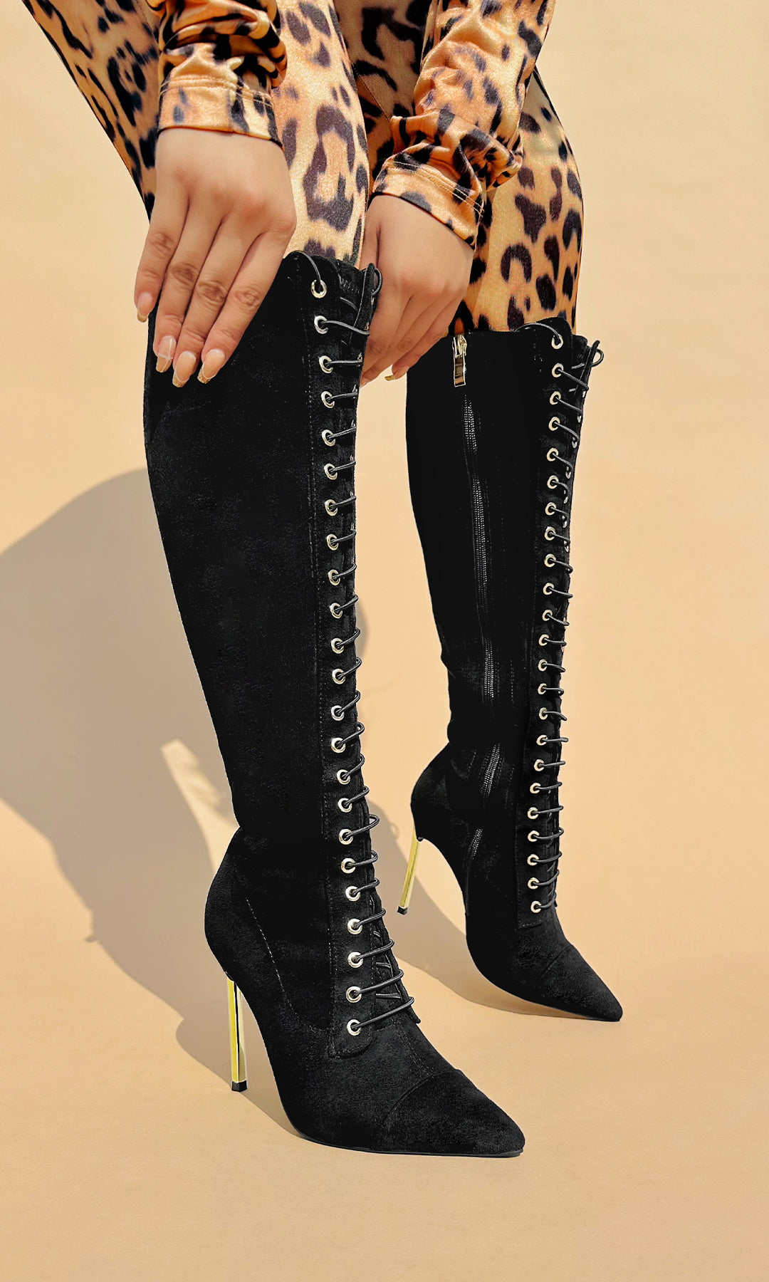 ANTONIA CHICA POSA BOTAS DE TACON CROMADO SOBRE CICLORAMA CAFE CON TRAJE COMPLETO DE ESTAMPADO DE LEOPARDO PARA MUJER