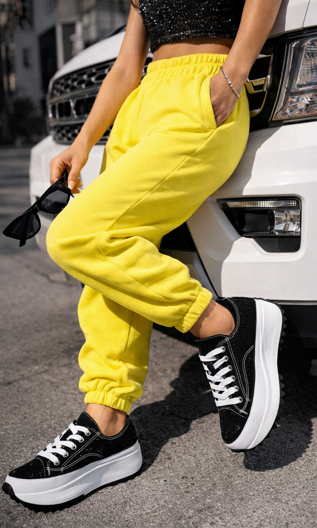 ASTRAL MODELO POSA EN CAMIONETA TENIS NEGROS DE PLATAFORMA CON PANTS AMARILLOS Y TOP DE BRILLOS PARA LUCIR LOOK URBANO
