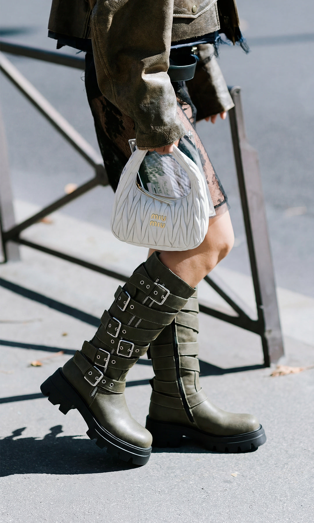 BIKER STREET STYLE LOOK COMBINANDO BOTAS VERDE OLIVO SUELA TRACK CON CAZADORA DE VINIPIEL ENCIMA DE VESTIDO NEGRO Y BOLSO BLANCO