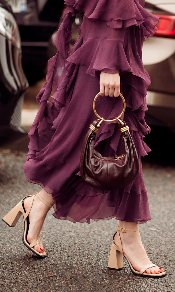 BOLD OUTFIT PARA USAR EN EVENTOS SOCIALES DE NOCHE LUCIENDO ZAPATILLAS COLOR NUDE DE PULSERA CON VESTIDO DE VOLANTES MORADO CIRUELA