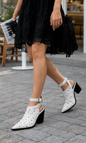 CHLOE CHICA COMBINA VESTIDO NEGRO CON DETALLES DE ENCAJE A JUEGO CON BOTINES BLANCOS DESTALONADOS PARA VERSE TRENDY EN SALIDAS 