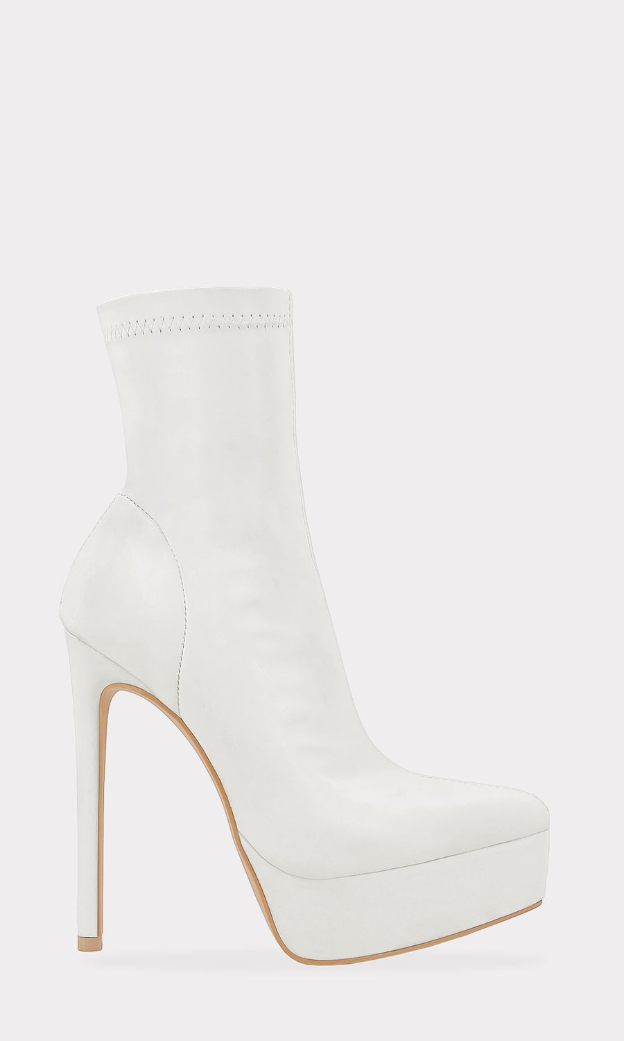 COUGAR MODELO POSA BOTINES BLANCOS CON BLUSA DE MANGA LARGA SOBRE PISO DE MADERA PARA LLEVAR AUN BRUNCH CON AMIGAS