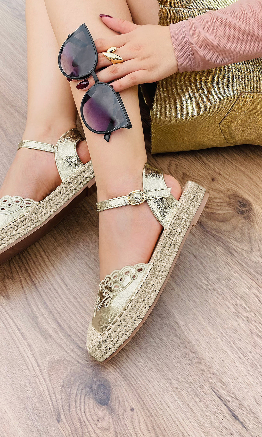 FERNIE ALPARGATAS DE PISO DORADAS CON FALDA CORTA BLUSA DE MANGA LARGA Y LENTES DE SOL PARA USAR EN UN BRUNCH CON AMIGAS