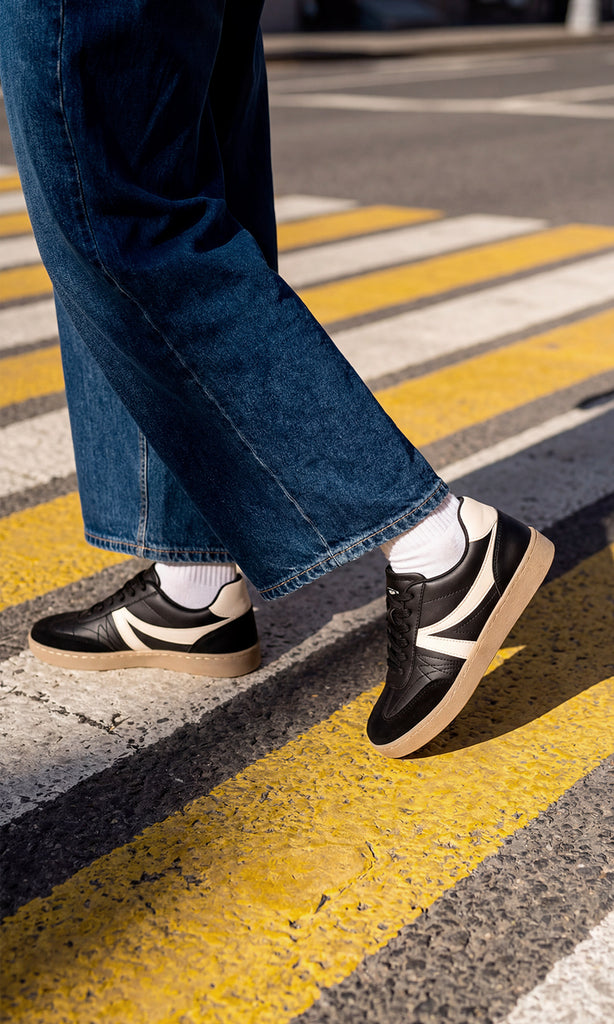 GIANNA MODELO POSA EN LA CALLE SNEAKERS NEGROS CON PANTALON AZUL MARINO DE MEZCLILLA Y CAMISA BLANCA PARA LUCIR EN TENDENCIA