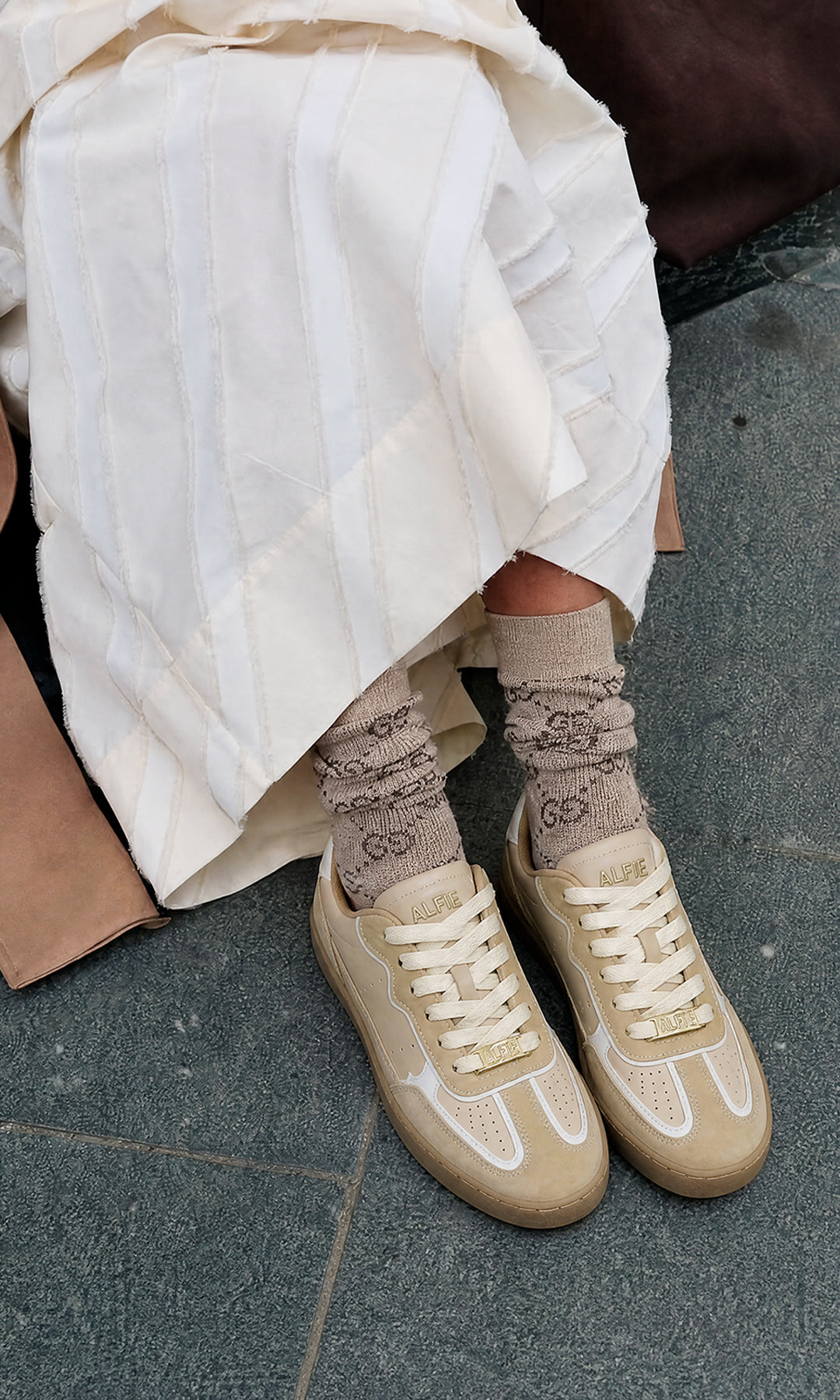 KAIA STREET STYLE LOOK LUCIENDO FALDA LARGA COLOR BLANCO MARFIL CON GABARDINA CAMEL ENCIMA DE TOP Y TENIS COLOR NUDE