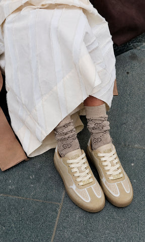 KAIA STREET STYLE LOOK LUCIENDO FALDA LARGA COLOR BLANCO MARFIL CON GABARDINA CAMEL ENCIMA DE TOP Y TENIS COLOR NUDE