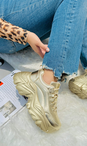 LISETTE MODELO POSA TENIS CHUNKY DORADOS CON PANTALON DE MEZCLILLA Y BLUSA DE MANGA LARGA ESTAMPADO DE LEOPARDO PARA EL DIA CHICA