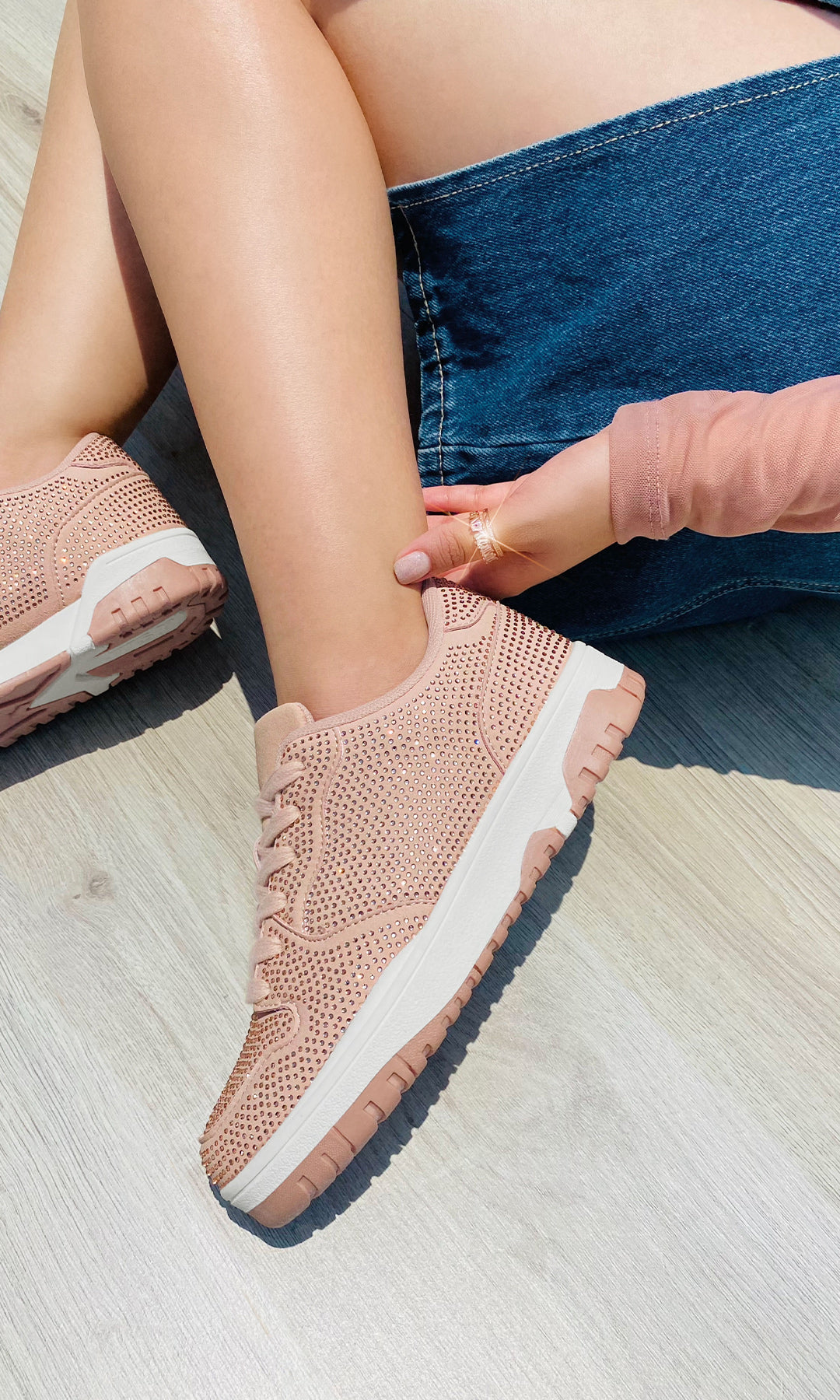 MARISELLE MODELO POSA SOBRE PISO TENIS ROSAS CON BRILLOS COMBINADOS CON FALDA DE MEZCLILLA Y BLUSA DE MANGA LARGA ROSA FASHION
