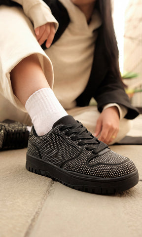 MARISELLE STREET STYLE LOOK USANDO TENIS NEGROS DE BRILLOS CON CONJUNTO DEPORTIVO COLOR BEIGE Y ABRIGO NEGRO 