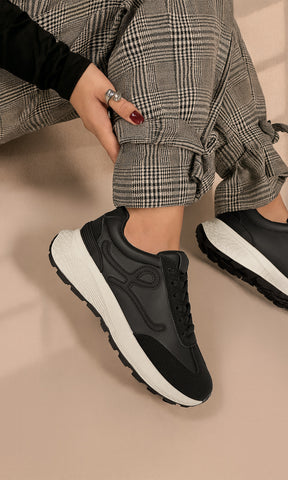 MELINE CHICA COMBINA TENIS NEGROS DE PLATAFORMA CON BLUSA DEL MISMO COLOR Y PANTALON GRIS CON ESTAMPADO DE CUADROS 