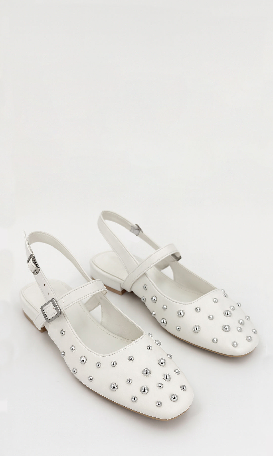 MINETTE ZAPATO CASUAL COLOR BLANCO DE PUNTA REDONDA ESTOPEROLES METÁLICOS STRAP EN EMPEINE TACÓN KITTEN 2 CM DISEÑADO PARA USAR EN LOOKS DIARIOS 