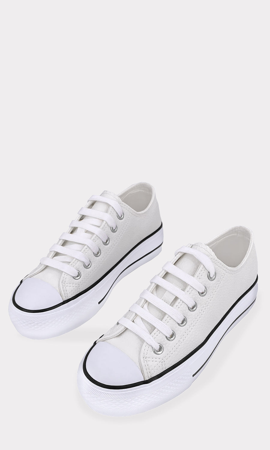 Tenis blancos de plataforma con agujetas y suela gruesa, combinados con conjunto de mezclilla azul para un look casual y urbano para mujer
