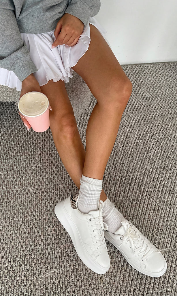 NOVILLE OUTFIT SPORT-CHIC PARA USAR EN EL GIMNASIO LUCIENDO TENIS BLANCOS CON DETALLES SNAKE A JUEGO DE FALDA Y SUDADERA GRIS OVERSIZE 