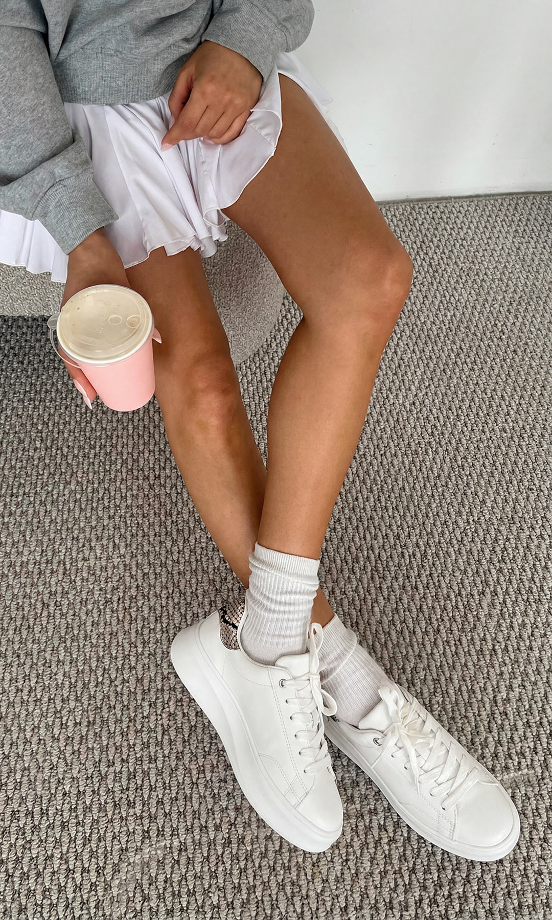 NOVILLE OUTFIT SPORT-CHIC PARA USAR EN EL GIMNASIO LUCIENDO TENIS BLANCOS CON DETALLES SNAKE A JUEGO DE FALDA Y SUDADERA GRIS OVERSIZE 