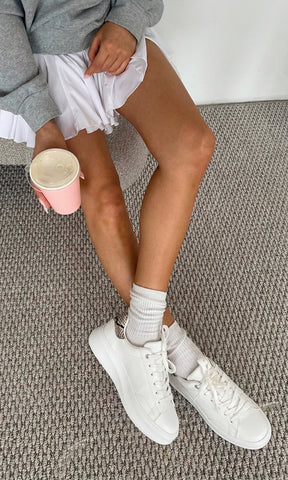 NOVILLE OUTFIT SPORT-CHIC PARA USAR EN EL GIMNASIO LUCIENDO TENIS BLANCOS CON DETALLES SNAKE A JUEGO DE FALDA Y SUDADERA GRIS OVERSIZE 