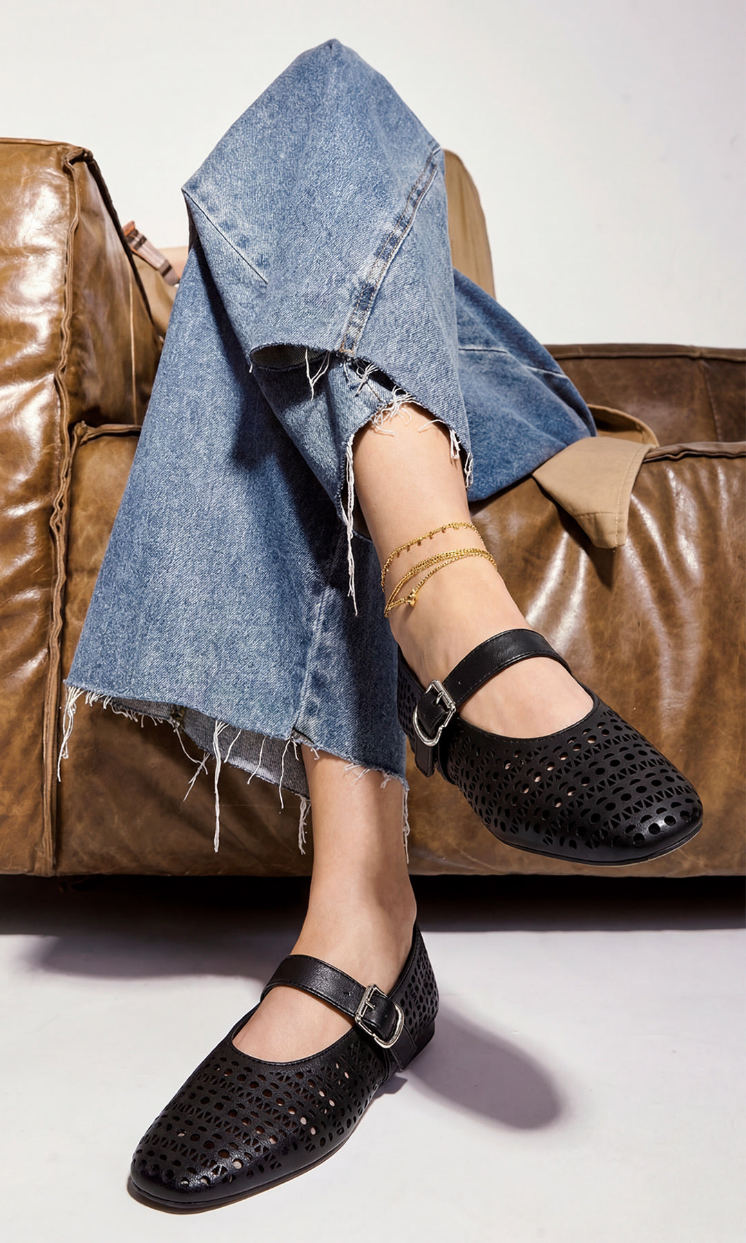 PENNY CÓMO COMBINAR ZAPATOS NEGROS MARY JANE LASER CUT CON PANTALONES DE MEZCLILLA MIENTRAS POSA SENTADA EN SILLON VINTAGE