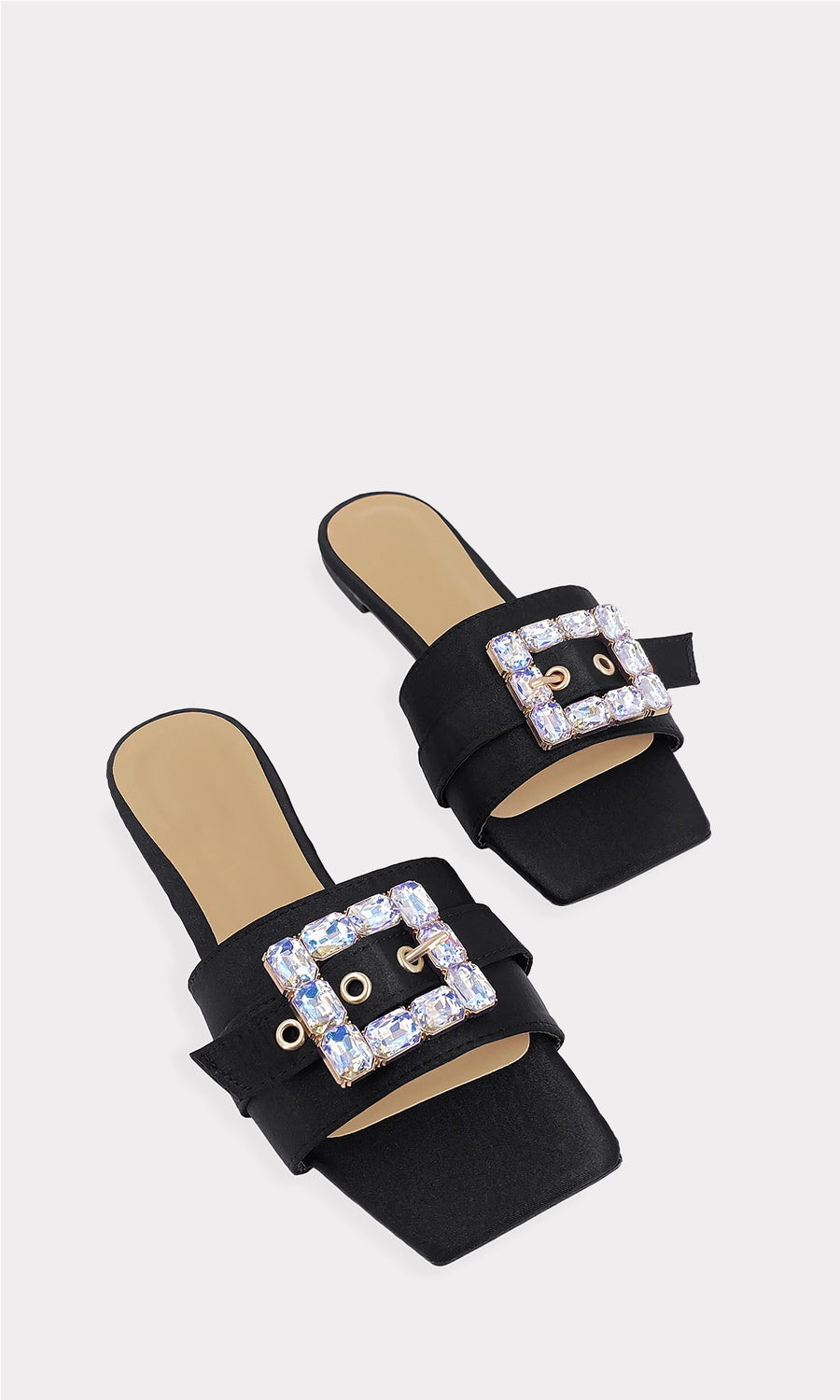 SALMA MODELO POSA SANDALIAS NEGRAS CON HEBILLA DE PEDRERIA CON FALDA DORADA Y BLUSA NEGRA DE MNAGA LARGA EN TEDENCIA DE MODA