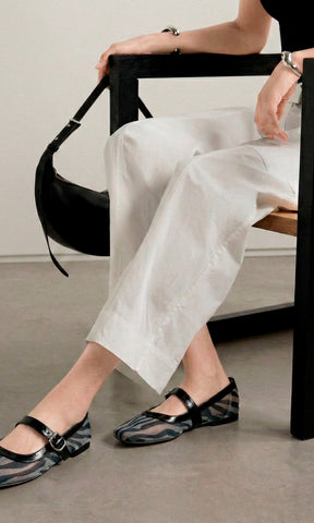 SOLSTICE CHICA COMBINA FLATS DE MESH CON ESTAMPADO DE CEBRA MIENTRAS COMBINA PANTALON BLANCO Y TOP NEGRO A JUEGO DE BOLSO