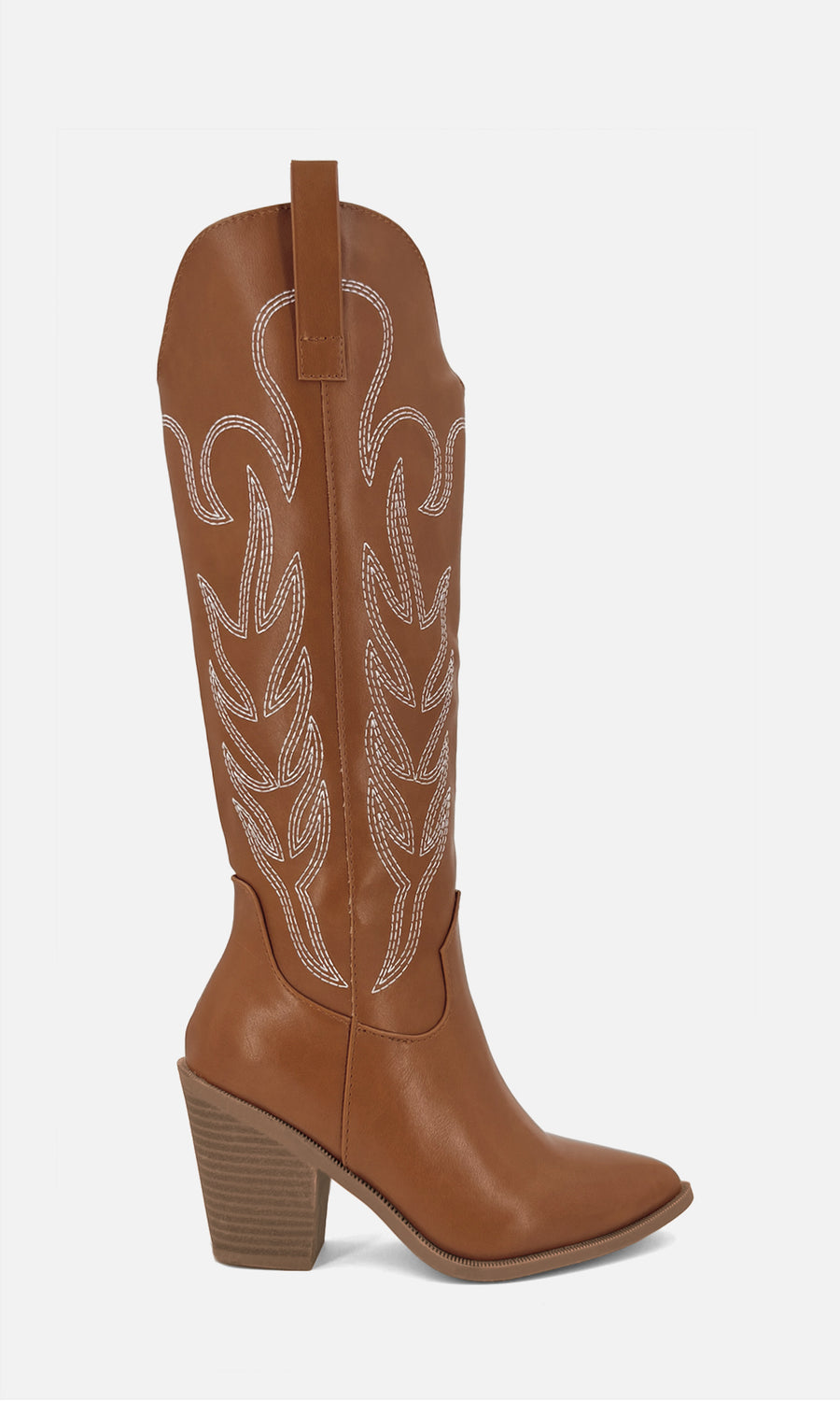 Botas vaqueras altas color camel con punta afilada, tacón ancho y bordado western, combinadas con shorts camel, suéter claro y bolso a tono en un look casual