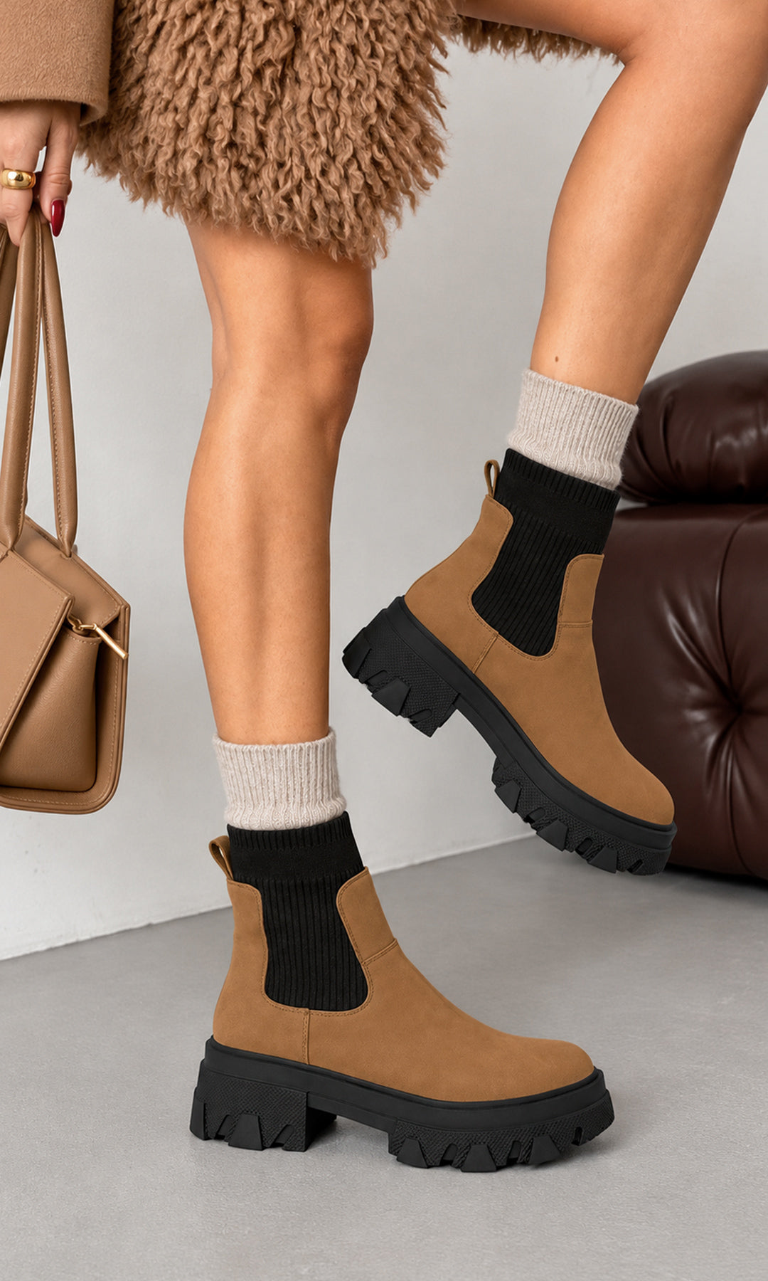 Botines Chelsea Ashton camel con caña elástica negra y plataforma dentada de inspiración chunky, estilizados con calcetas beige y abrigo de textura afelpada