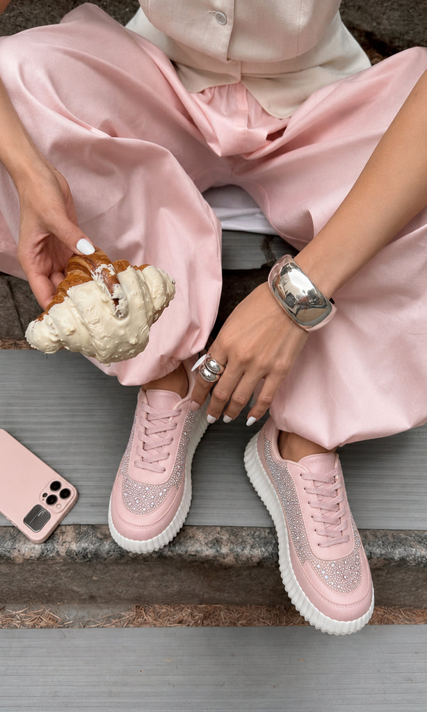 Tenis BRIGITTE rosas con pedrería brillante, agujetas al tono y suela plataforma blanca, combinados con pantalón rosa satinado en un look femenino casual