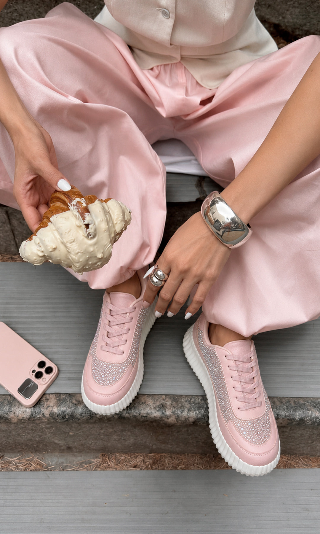Tenis BRIGITTE rosas con pedrería brillante, agujetas al tono y suela plataforma blanca, combinados con pantalón rosa satinado en un look femenino casual