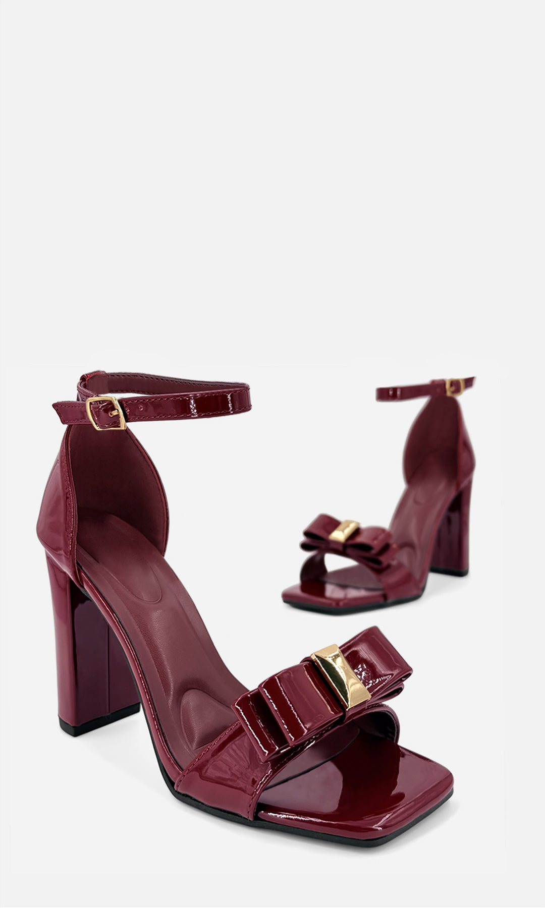 Par de zapatillas de tacón CHERRY ROJO VINO de charol en vista 3/4, con moño frontal, joyería dorada, pulsera al tobillo y tacón ancho de 9.5 cm