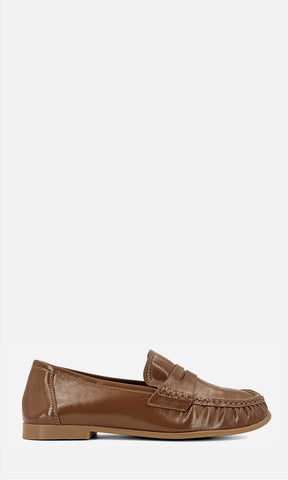 Mocasín tipo penny loafer DANDY CAMEL de vinipiel en vista de perfil, con antifaz frontal, costuras tipo mocasín y tacón bajo de 1.5 cm