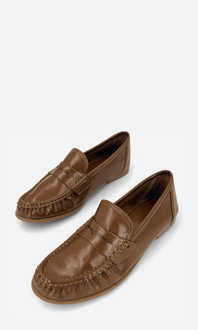 Par de mocasines tipo penny loafer DANDY CAMEL de vinipiel en vista 3/4, con antifaz frontal, costuras tipo mocasín y tacón bajo de 1.5 cm