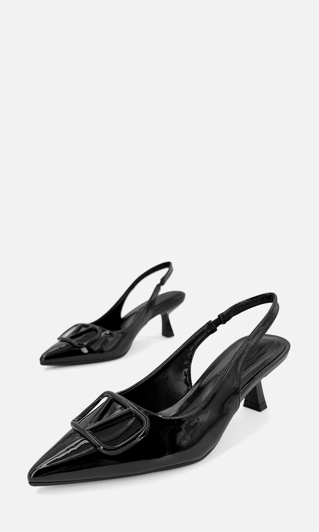 Par de zapatillas slingback EDITORIAL NEGRO de charol en vista 3/4, con punta afinada, aplique joya 3D frontal y tacón fino de 6 cm