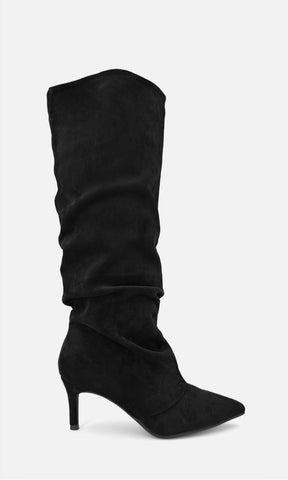 Bota alta tipo slouch FRAN NEGRO de gamuza en vista de perfil, con caña drapeada, punta afinada y tacón fino de 7.5 cm
