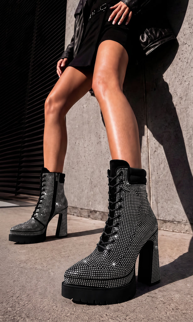 Modelo con vestido negro y chamarra de piel usando botines Gravity negros con cristales plata en una producción editorial contemporánea de My Shoes México.