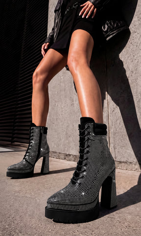 Modelo con vestido negro y chamarra de piel usando botines Gravity negros con cristales plata en una producción editorial contemporánea de My Shoes México.