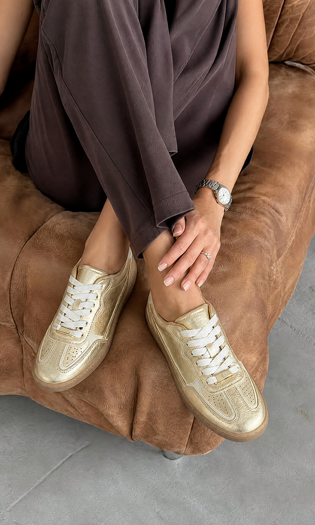 Modelo con pantalón amplio usando tenis Kaia dorados metálicos en una producción editorial casual de My Shoes México.