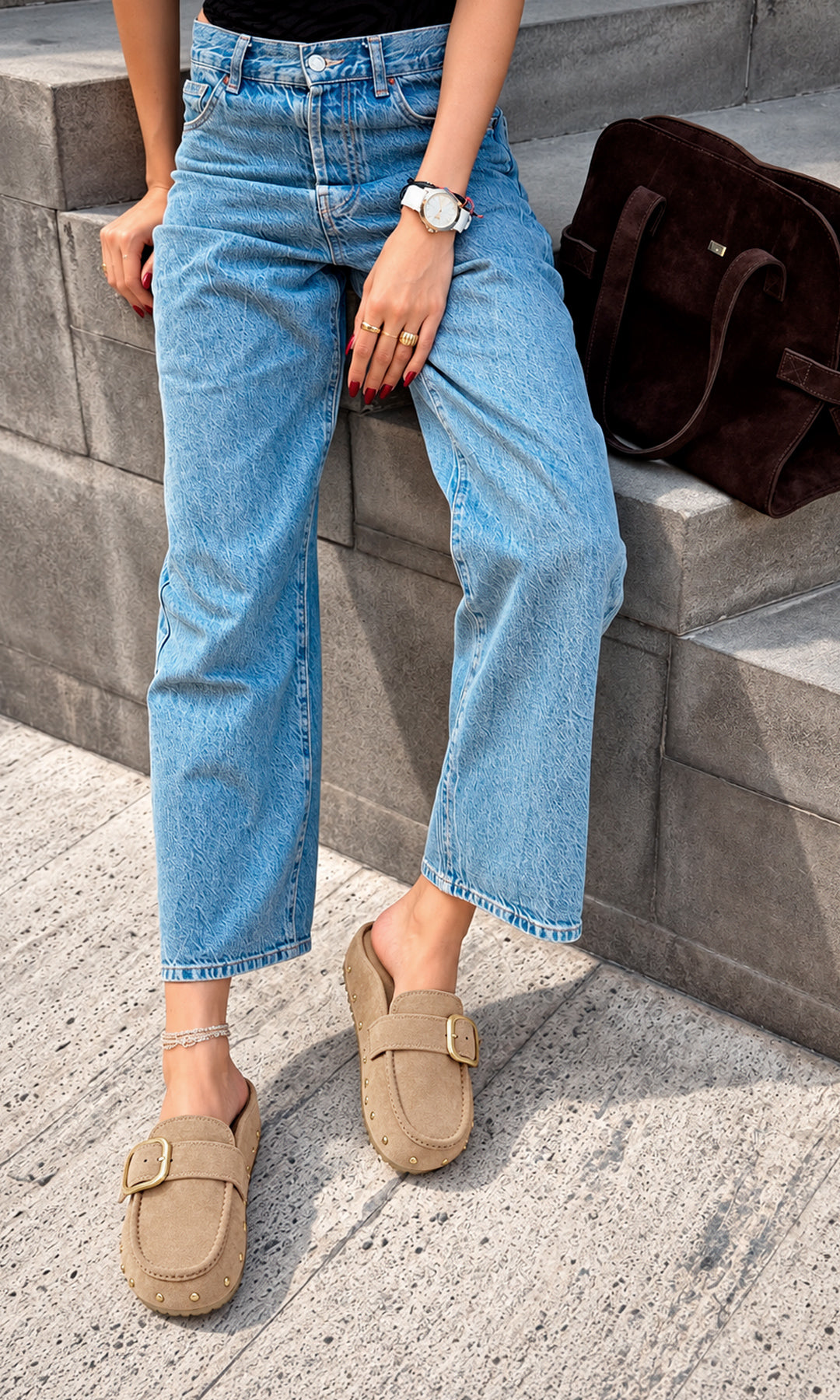 Mules nude con hebilla dorada y estoperoles, llevados con jeans de pierna amplia en un look casual urbano