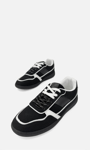 Par de tenis MATCHA NEGRO de gamuza y vinipiel en vista 3/4, con detalles blancos en contraste, agujetas bicolor y suela de 2.5 cm