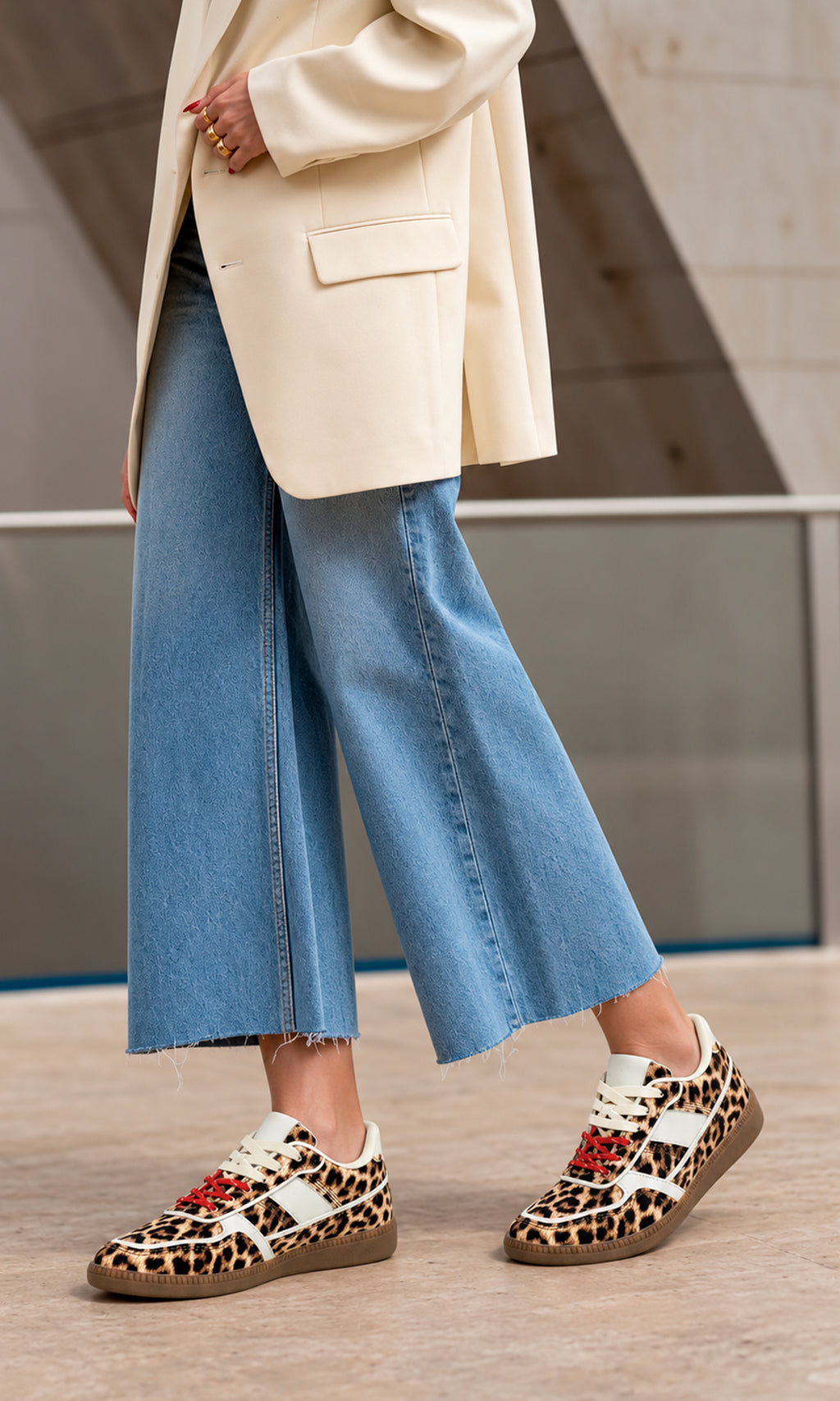 Sneakers Matcha con estampado de leopardo, silueta retro de perfil bajo, paneles blancos en contraste, agujetas rojos y suela de goma combinados con jeans cropped de pierna ancha