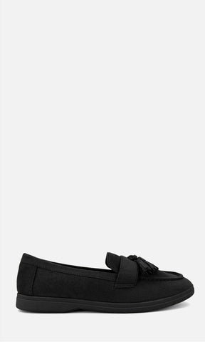 Mocasín SINATRA NEGRO de gamuza en vista lateral, con borlas decorativas frontales, silueta clásica y tacón bajo de 2 cm