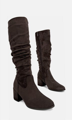 Botas largas NURI CAFÉ de gamuza color café con diseño pointy y tacón bajo de 6.5 cm, mostradas en vista tres cuartos