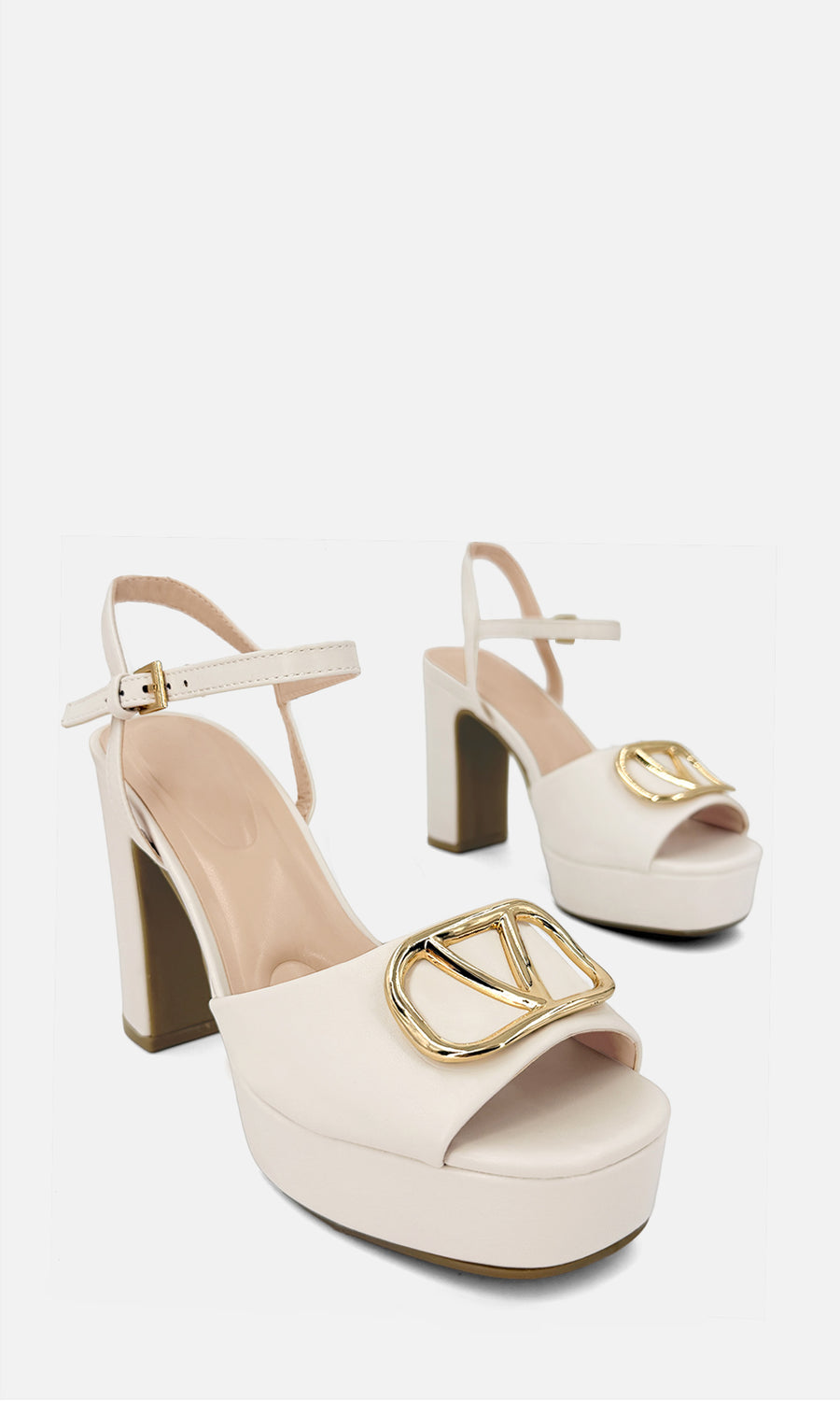 Zapatillas marfil de plataforma con tacón ancho, punta abierta, pulsera al tobillo y adorno dorado al frente, combinadas con blazer crema en un look elegante