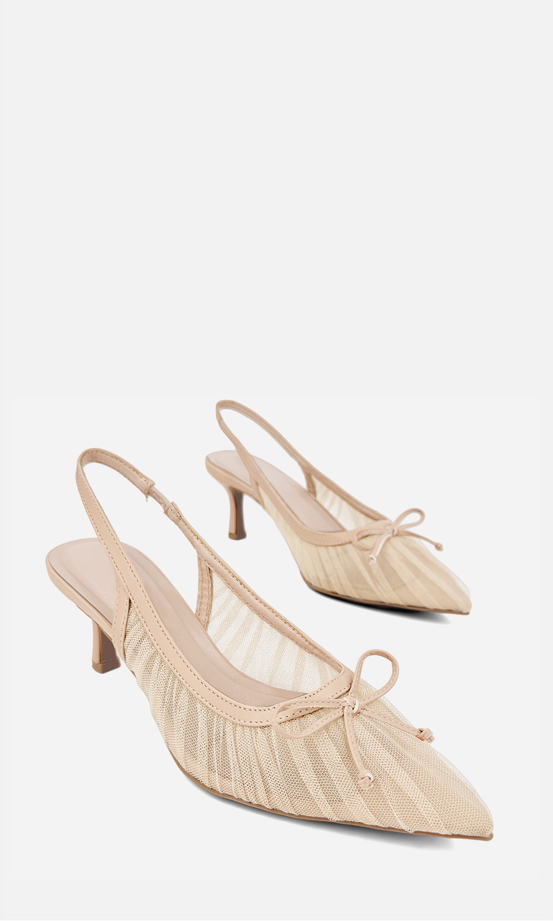 Par de zapatillas slingback PREMIERE NUDE de vinipiel y mesh en vista 3/4, con punta afinada, moño frontal, transparencias y tacón fino de 6.5 cm