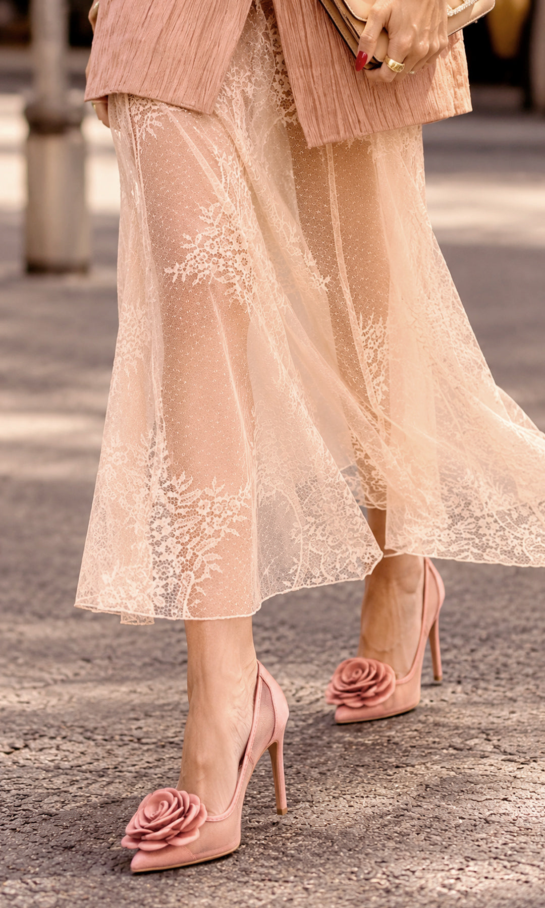 Pump Rosabelle en rosa empolvado, con cuerpo de malla transparente, punta fina, tacón stiletto delgado y gran flor tridimensional a tono sobre la parte delantera del zapato