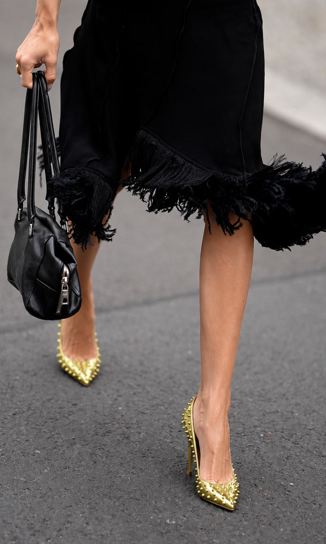 Zapatillas ROXY doradas de punta con tacón alto de aguja y estoperoles metálicos, combinadas con vestido negro de flecos en un look sofisticado
