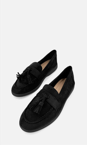 Par de mocasines SINATRA NEGRO de gamuza en vista 3/4, con borlas frontales, empeine estructurado y diseño clásico en color negro