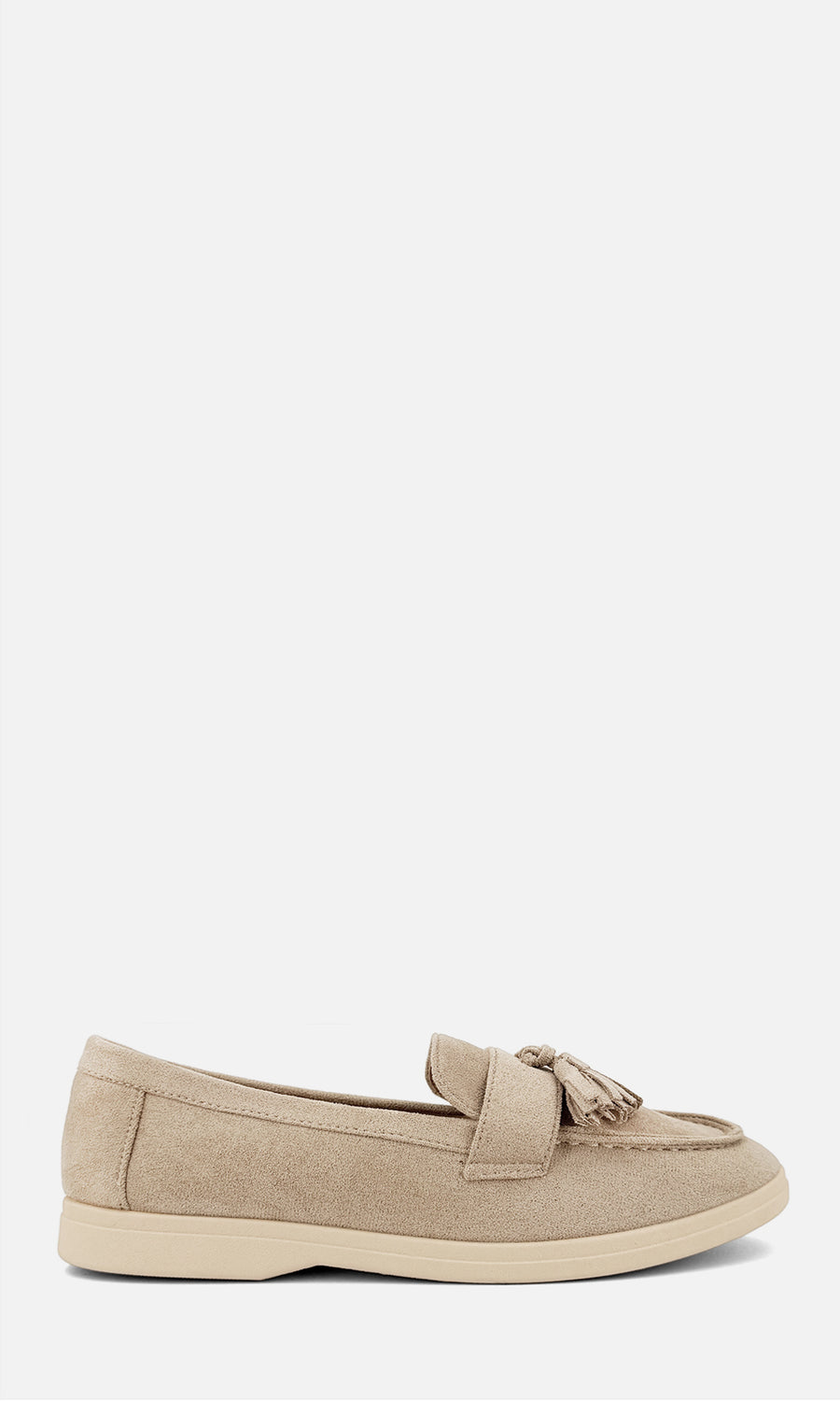 Mocasines nude con borlas y acabado tipo gamuza, combinados con pantalón crema y chaqueta caqui en un look casual de tonos neutros