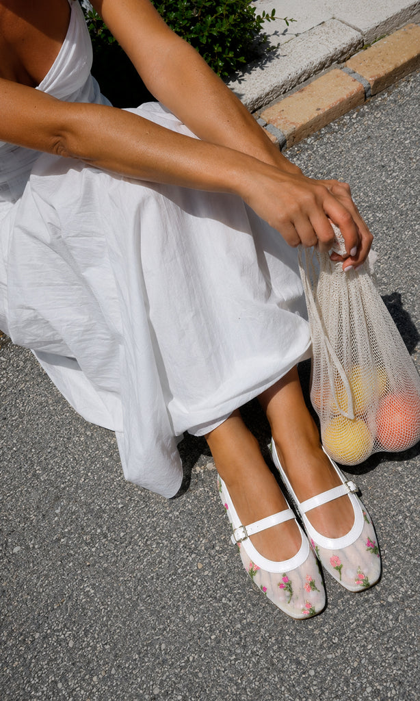 Flats SUGAR blancos tipo Mary Jane con mesh transparente y flores bordadas, combinados con vestido blanco para un look fresco y femenino.