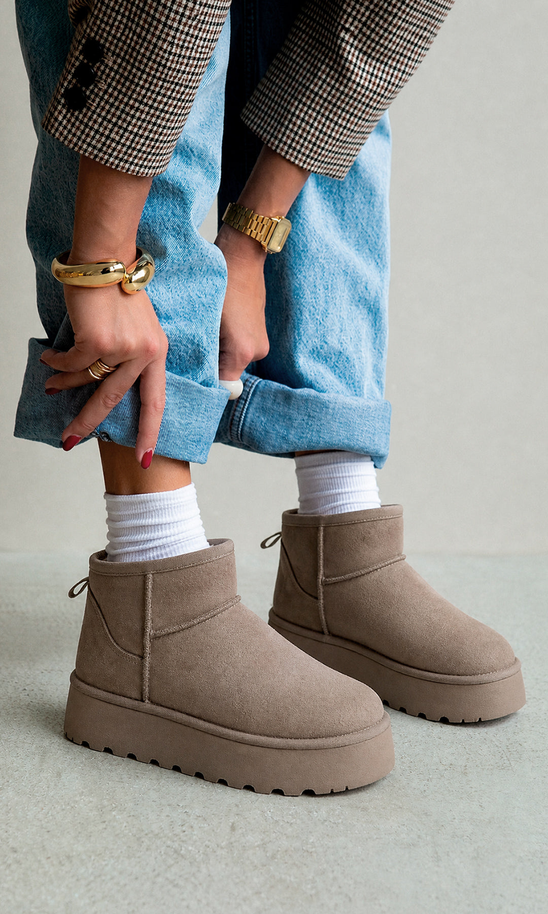 Botines WINTER taupe de gamuza con plataforma y suela gruesa, combinados con jeans claros, calcetas blancas y blazer a cuadros en un look casua
