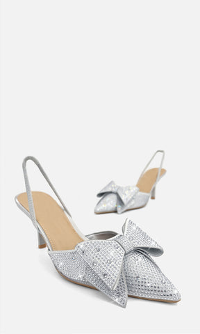 Zapatillas DANNA color plata de satín con aplicación de brillos, moño XL al frente, punta puntiaguda y tacón de 7.5 cm para ocasiones especiales